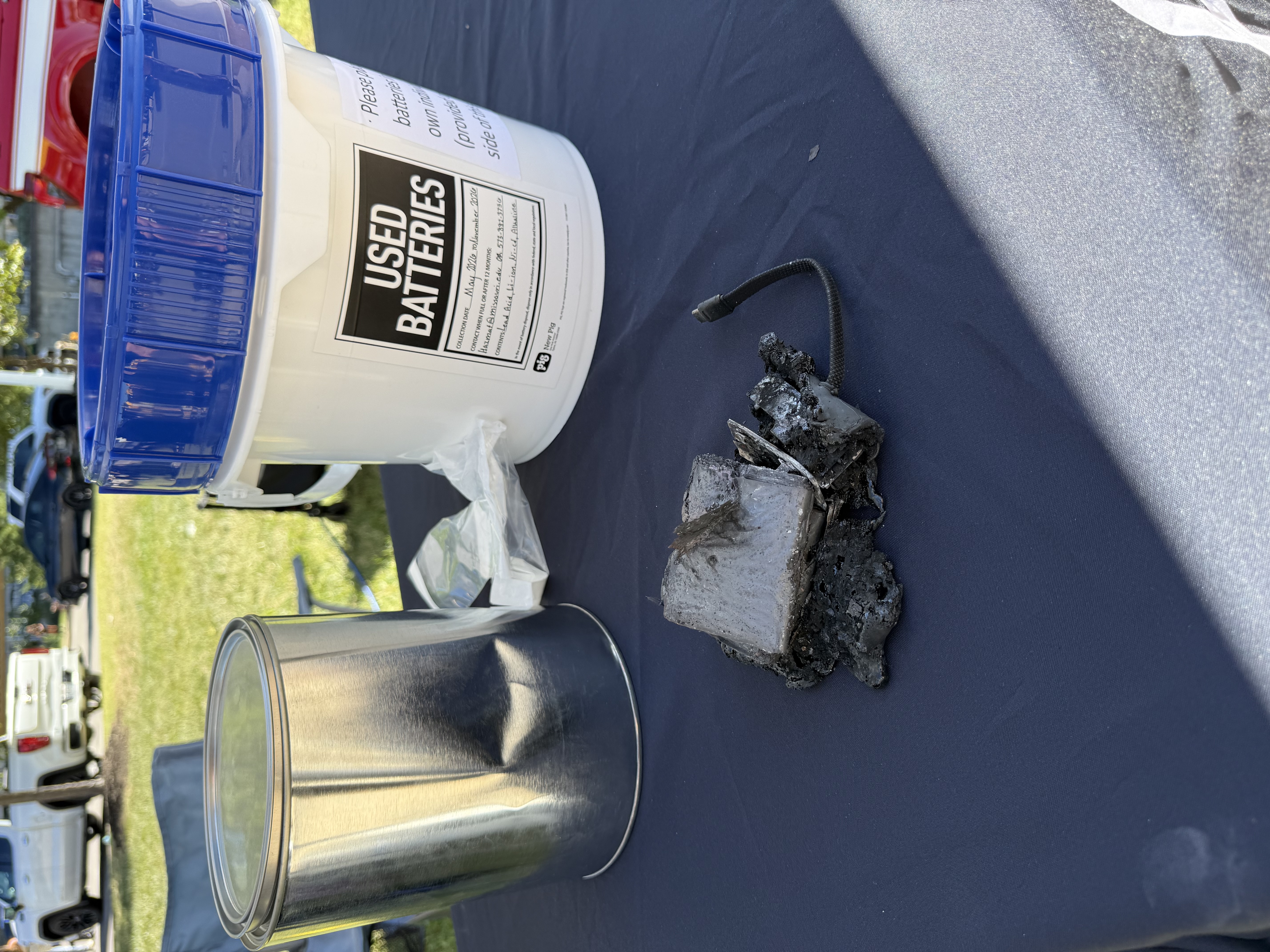 Two buckets and a burned lithium-ion battery on a table